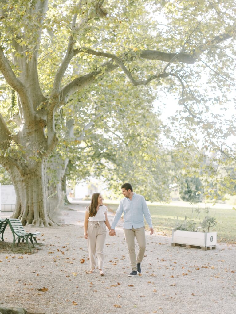 Couple walking hand in hand through the botanical garden during Switzerland engagement photos