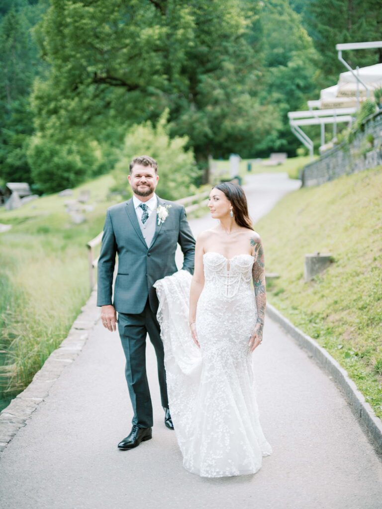 Couple walking together along the lakeshore as they elope in Switzerland